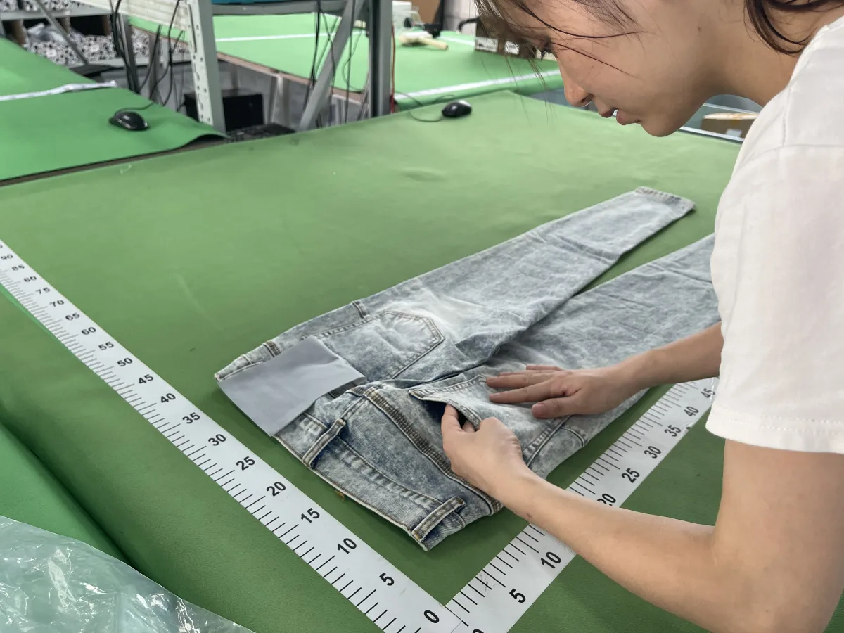Fishgoo team checking garment measurements at the China warehouse